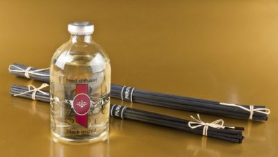 two bundles of PAIRFUM Reed Diffuser Sticks or Reed Diffuser Refill Reeds lying beside a bottle of reed diffuser refill oil