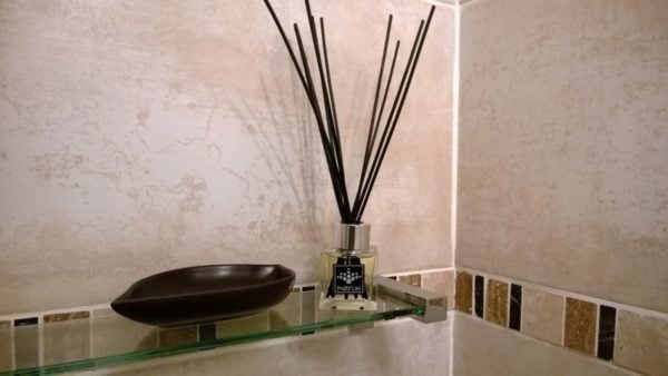 PAIRFUM luxury and natural reed diffuser on a shelf of a modern bathroom