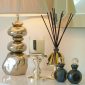 PAIRFUM luxury scented candle and natural reed diffuser on a side table