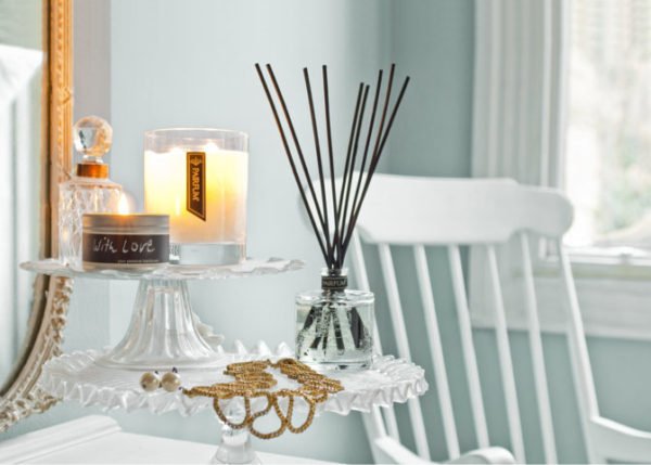 PAIRFUM luxury scented candle and natural reed diffuser on a side table in a French cottage