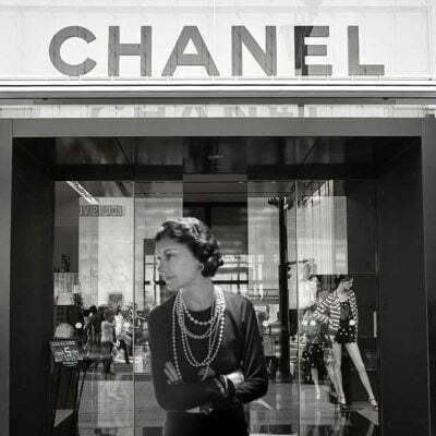 Chanel standing in the entrance of her Paris boutique