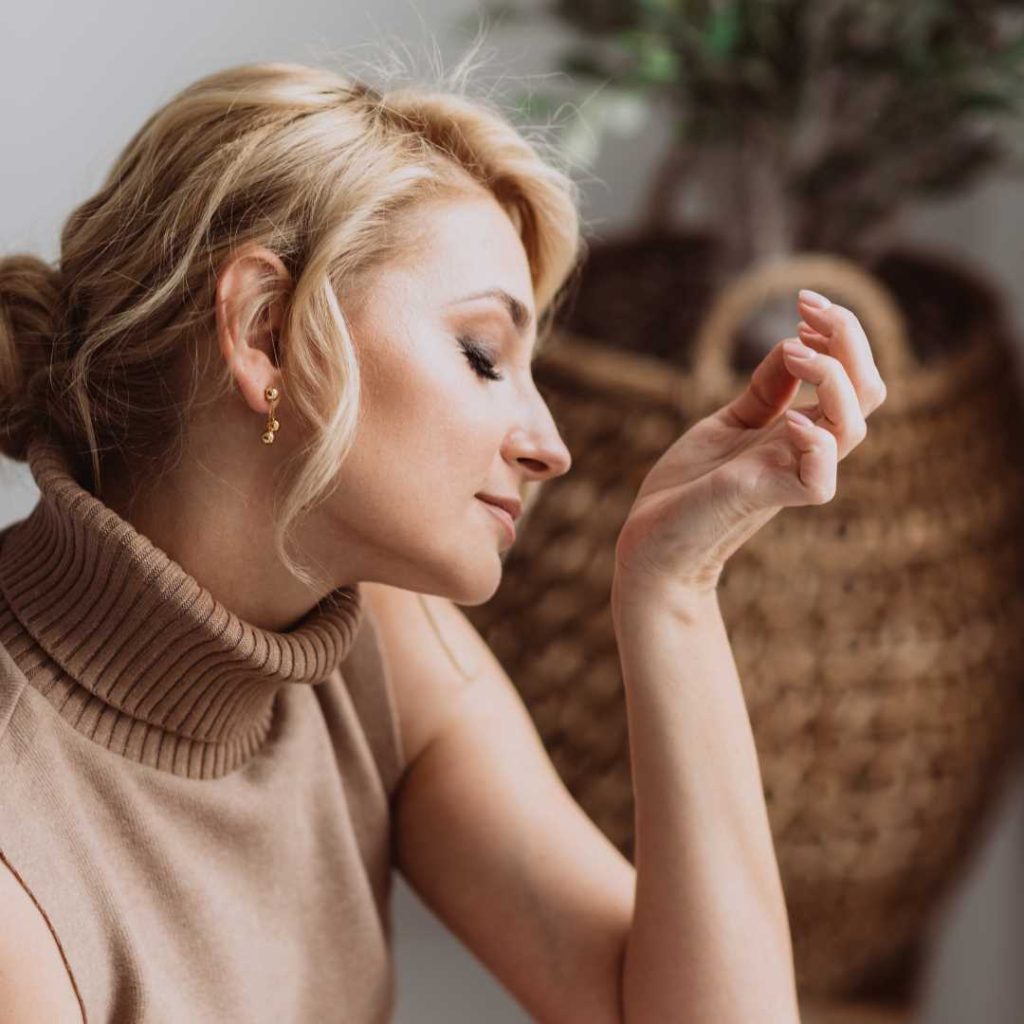 custom perfume layering; a woman smelling her wrist