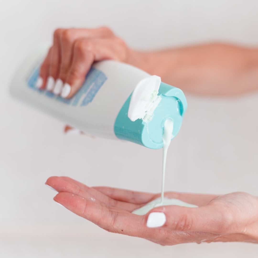 Prebiotic lotion benefits, pouring lotion in hand.