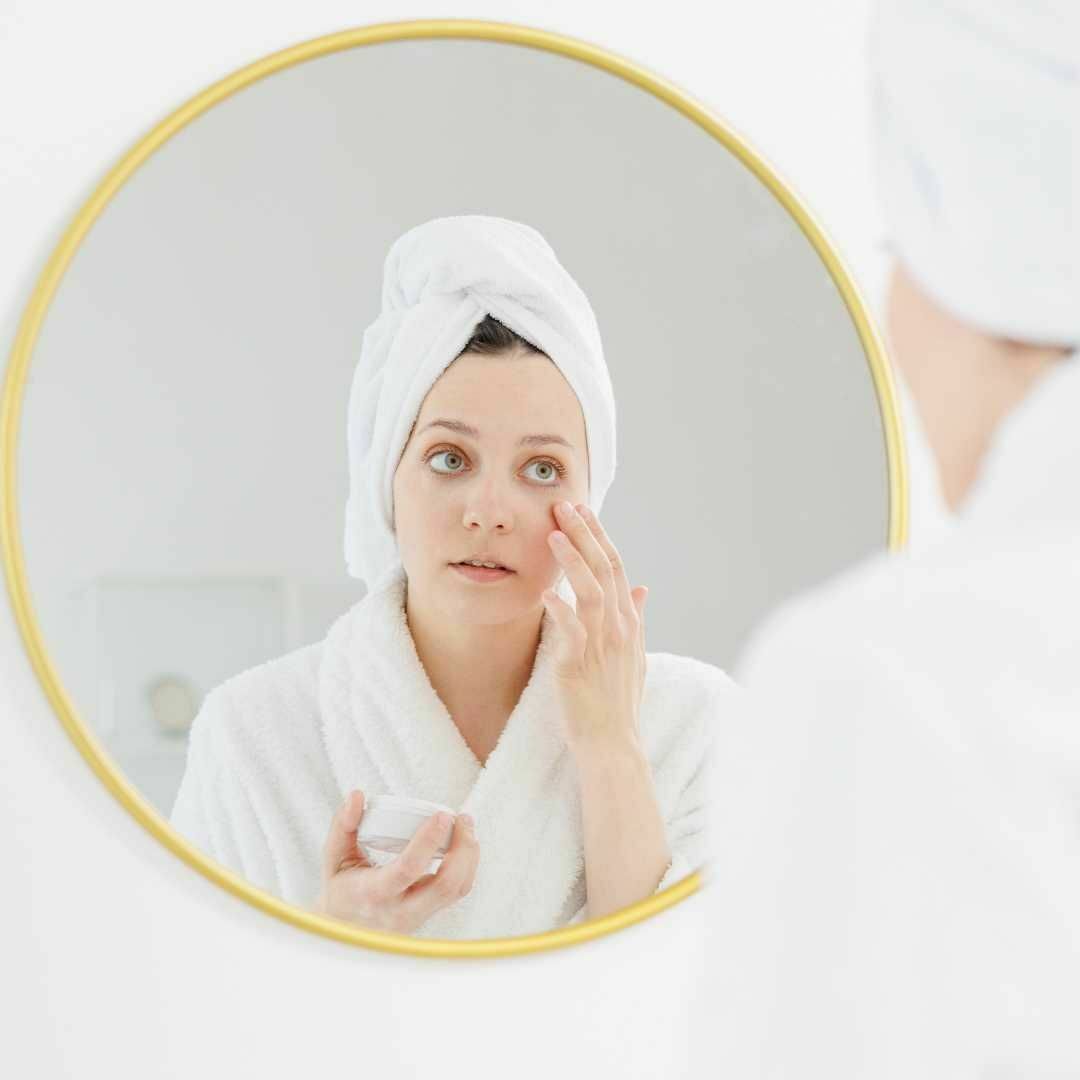 Prebiotic lotion benefits, woman applying face lotion.